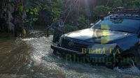 Sejumlah Desa di Gunung Mas Terendam Banjir, Babinsa Pandu Warga Seberangi Jalan