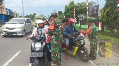 Anggota Koramil Timika Bagikan Bendera Merah Putih Bagi Pengguna Jalan