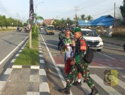 Babinsa Koramil Jajaran Kodim 1710/Mimika Bantu Pelajar Seberang Jalan